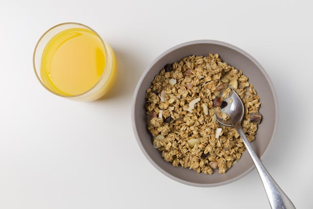 a bowl of oats and glass of orange juice