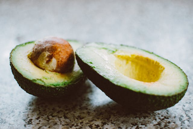 avocado cut in half on a table top